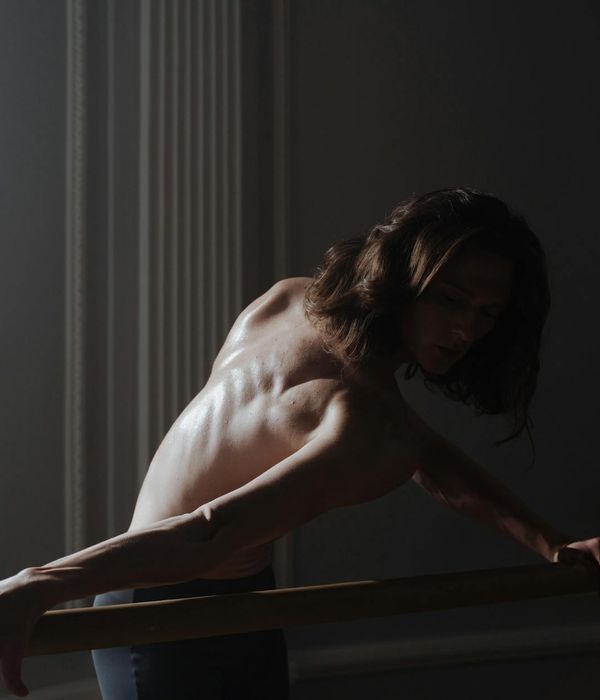 Person practicing gentle movements in a dark studio